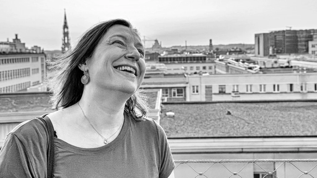 Femme riant sur un toit de Bruxelles, exemple de photo de profil naturelle et vivante